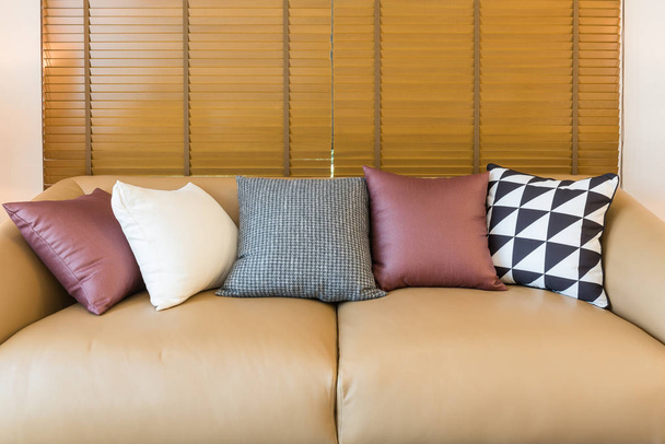 sofá marrón con almohadas de colores en estilo clásico de la sala de estar
 - Foto, imagen