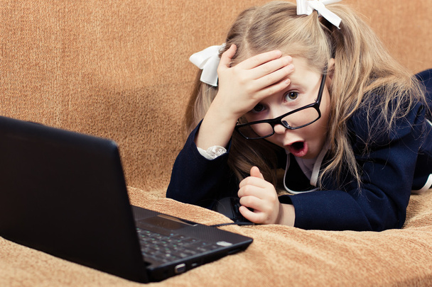 Child with a laptop in shock. - Foto, Imagen