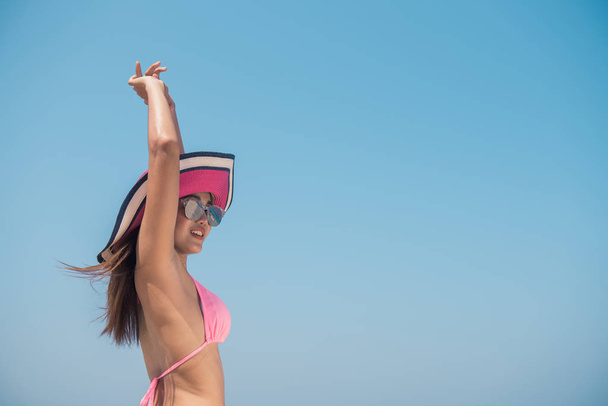 セクシーなビキニ体アジアの女性の遊び心のある楽しい楽園熱帯のビーチに両手を広げて自由に水しぶきを再生します。旅行休暇の美しいフィットのボディの女の子。コピー スペースのバナー作物. - 写真・画像