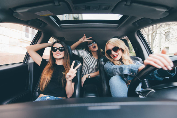 Grupa przyjaciół, zabawy na samochód. Śpiew i śmiejąc się w samochodzie drive w centrum miasta - Zdjęcie, obraz