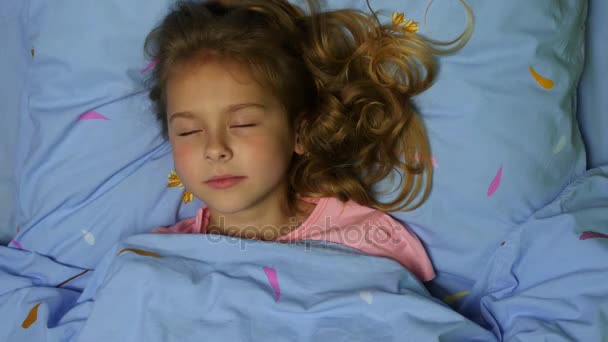Bovenaanzicht van een slapende meisje met lang krullend haar.  - Video