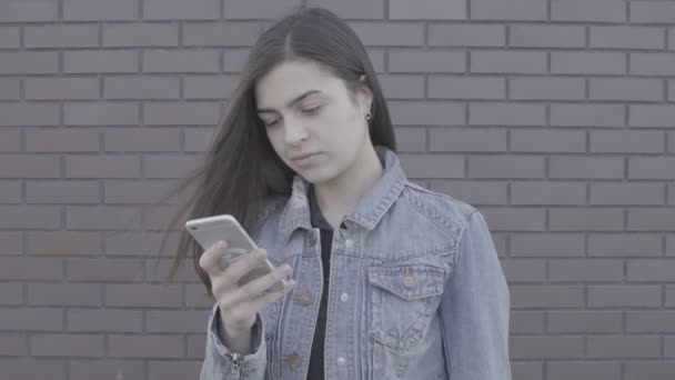attraktive junge Frau mit ihrem Touchscreen-Handy 4k - Filmmaterial, Video