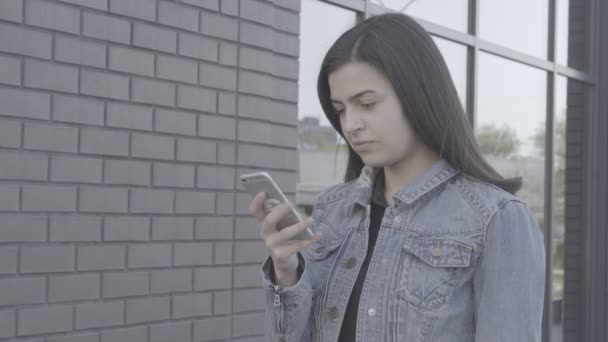 Vonzó fiatal nő segítségével a érint képernyő telefon 4k - Felvétel, videó