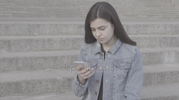 Attrayant jeune femme en utilisant son téléphone à écran tactile 4K
 - Séquence, vidéo