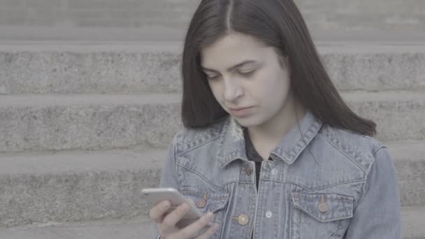 attraktive junge Frau mit ihrem Touchscreen-Handy 4k - Filmmaterial, Video