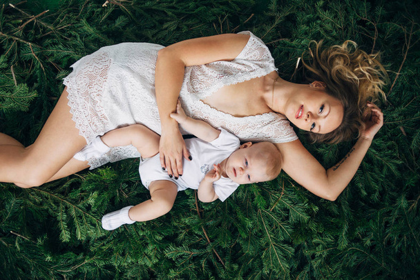 Mom and daughter are lying on Christmas trees - Photo, Image