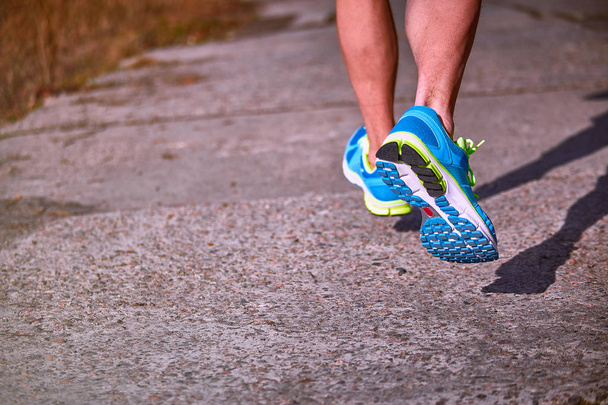 Πόδι αθλητή closeup τρέξιμο σε πάνινα παπούτσια σε εξωτερικούς χώρους. - Φωτογραφία, εικόνα