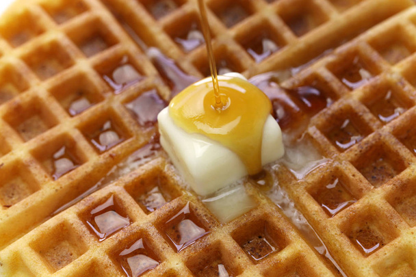 derramando xarope de bordo sobre waffles redondos americanos caseiros com manteiga
 - Foto, Imagem