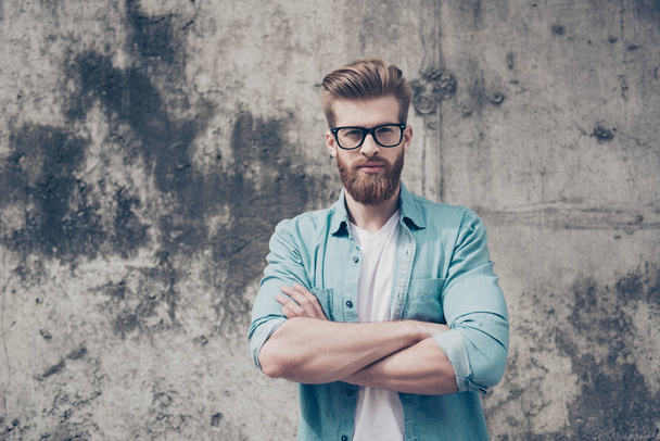 Nerdy handsome bearded young man is standing near the wall outdo - Foto, afbeelding