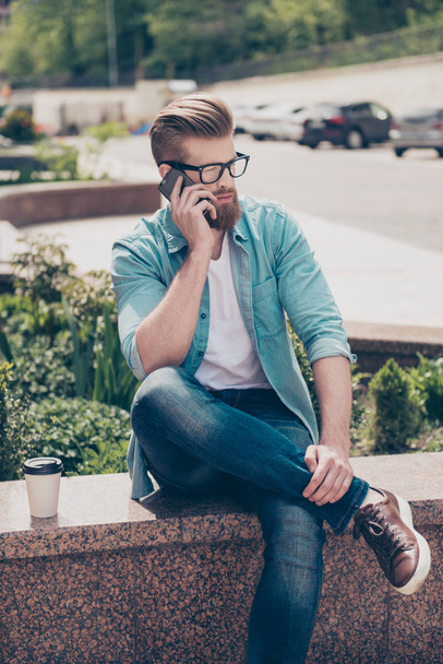Stylish young red bearded man in casual jeans outfit is talking  - 写真・画像