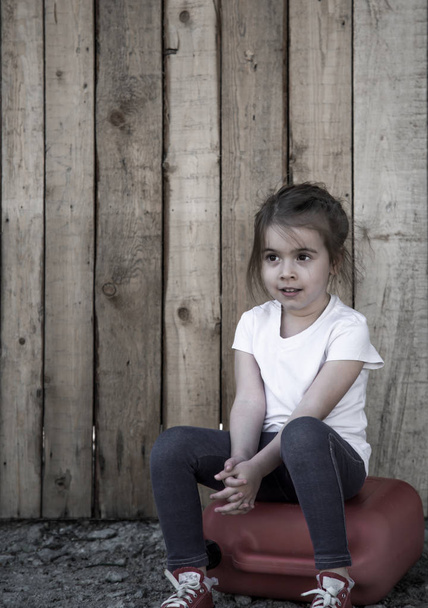 kis lány ül a fa háttér - Fotó, kép