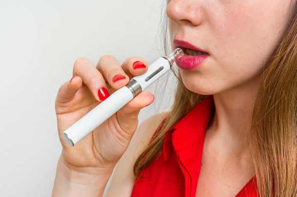 Close up of a woman holding and smoking e-cigarette - Photo, Image