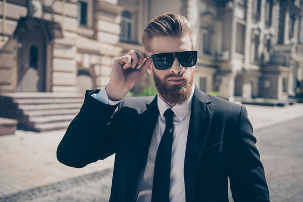Close up of a famous guy in formal wear and sunglasses outdoors. - Foto, Bild