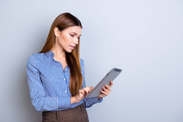 Young attractive business lady is holding tablet and typing on i - Foto, afbeelding