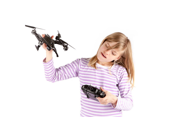 Girl playing with drone and its remote control. Isolated on whit - Φωτογραφία, εικόνα
