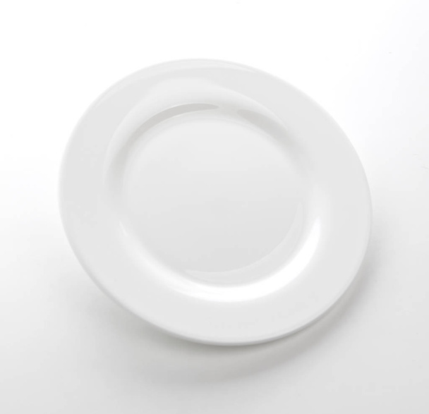 Біла тарілка ізольована на білому столі, порожній шаблон страви
 - Фото, зображення