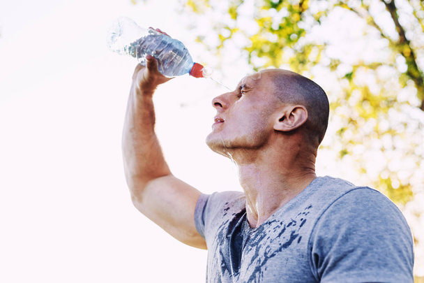 young athlete is refreshing himself with water, sport and healthy lifestyle - Photo, Image
