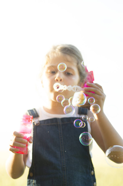 A young girl blowing bubbles - Photo, Image