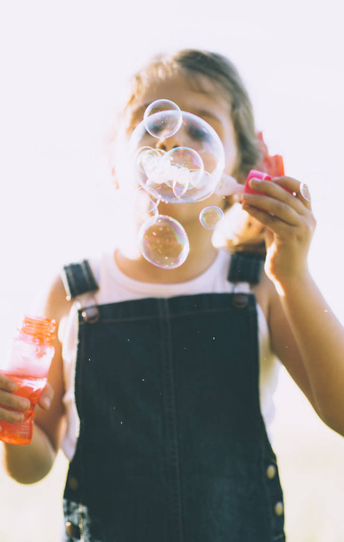 Egy fiatal lány buborékokat eregetett - Fotó, kép