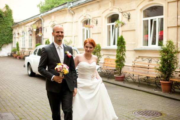 Bride looks over her shoulder while groom waits for her - Foto, Imagem