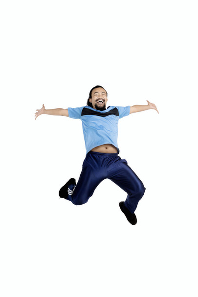 Young man leaping in studio  - Fotó, kép