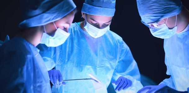 Chirurgo di squadra al lavoro in sala operatoria - Foto, immagini