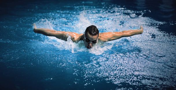 Male swimmer at the swimming pool. Underwater photo - 写真・画像