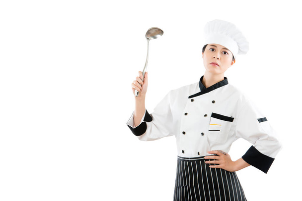 woman chef holding spoon showing on a copyspace - Foto, Imagem
