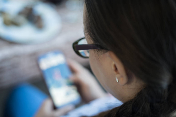 Smart Girl mit Brille nutzt Handy beim Essen - Foto, Bild