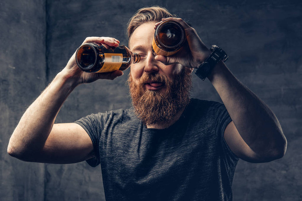 Uomo tiene due bottiglie di birra artigianale
  - Foto, immagini