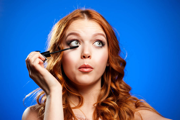 Young woman applying make up - 写真・画像