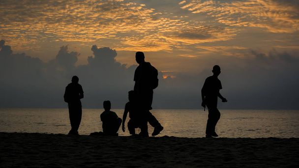 日の出にあるビーチ シルエット人  - 写真・画像