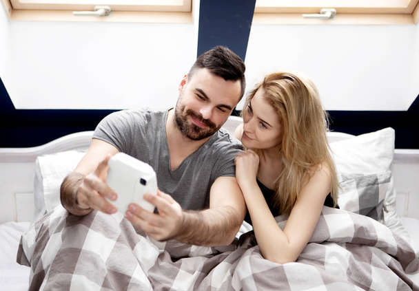 Couple taking selfie with instant camera at home. - Foto, Imagem