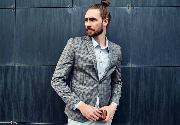 portrait of sexy handsome fashion male model man dressed in elegant checkered suit posing outdoors on the street background - Fotoğraf, Görsel