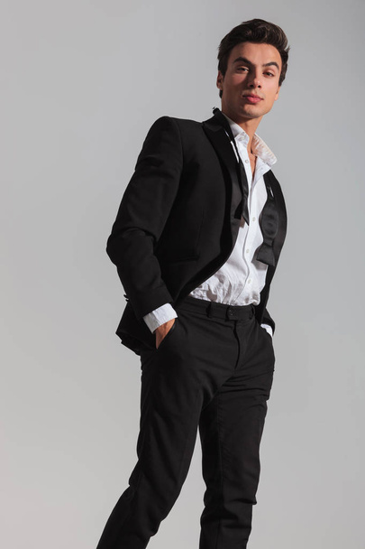 side view of an elegant man in tuxedo walking  - Foto, afbeelding