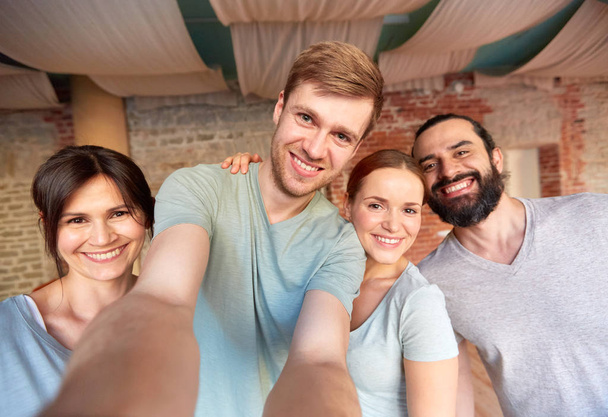 happy friends at yoga studio or gym taking selfie - Фото, изображение