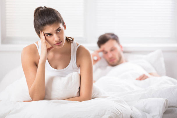 woman with unhappy look sitting in bed - Photo, Image