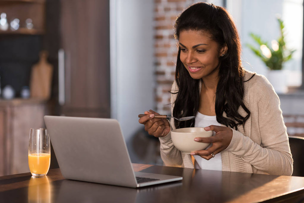 woman having breakfast and using laptop - Photo, Image