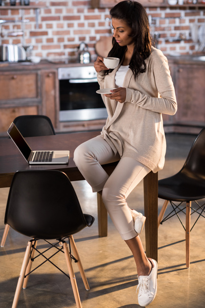 woman drinking coffee and using laptop - Foto, Imagen