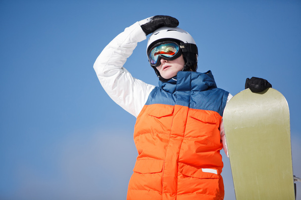 vrouwelijke snowboarder tegen zon en lucht - Foto, afbeelding