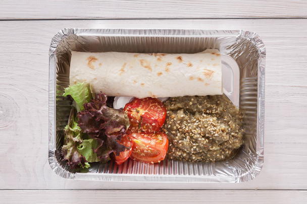 Aliments sains dans des boîtes de papier d'aluminium, concept de régime. Petit pain plat et tomates
 - Photo, image