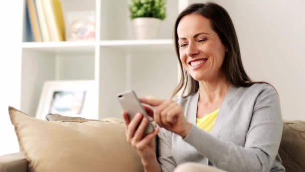 happy woman texting message on smartphone at home - Кадры, видео