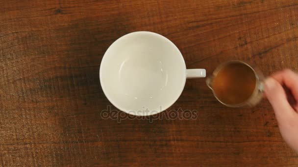 Баріста наливає карамельний сироп в чашці - Кадри, відео