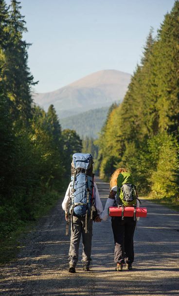 Couple hikers in the Carpathians mountains with backpacks. Summer time - Photo, Image