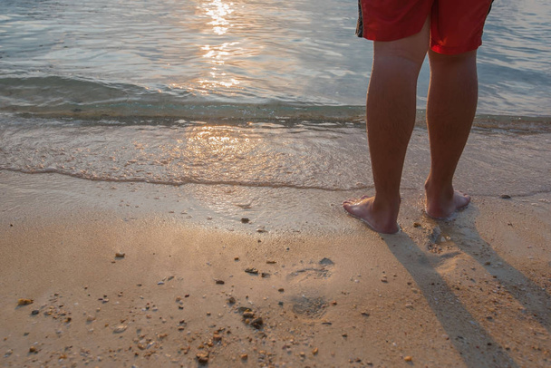 Hombre de pie en la playa junto al mar por la mañana
  - Foto, imagen