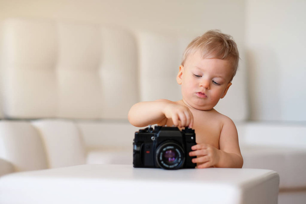 Criança explorando câmera antiga
 - Foto, Imagem