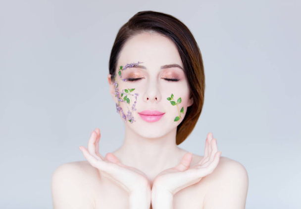 beautiful young woman with flowers on cheeks - Photo, image