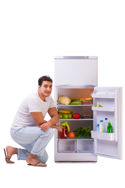 Homem ao lado do frigorífico cheio de comida
 - Foto, Imagem