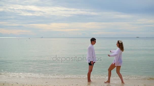 miłośników facet i dziewczyna biegną do siebie na plaży - Materiał filmowy, wideo