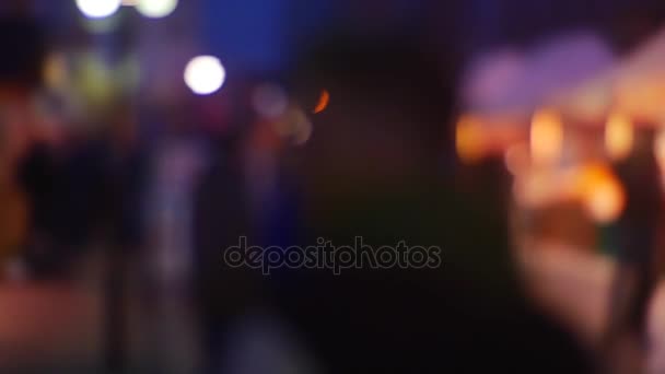 Занятая улица в Вечернем Городе с автомобильными фарами и темными силуэтами Люди размыли фон яркого цветного освещения. Вне фокуса, размытость
 - Кадры, видео